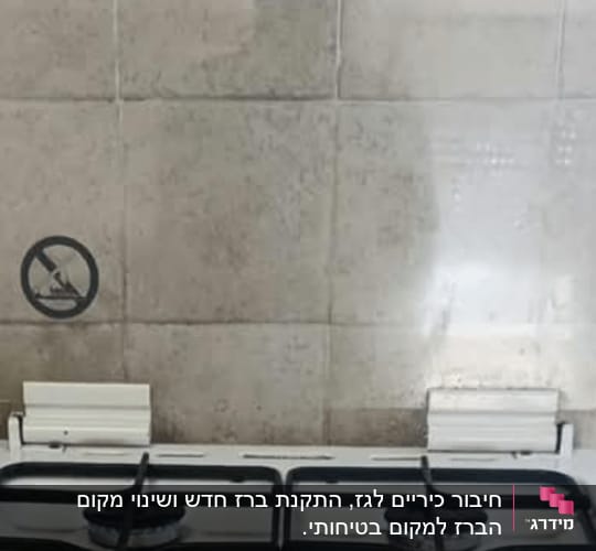 כיריים גז עם ארבעה מבערים על רקע קיר אריחים